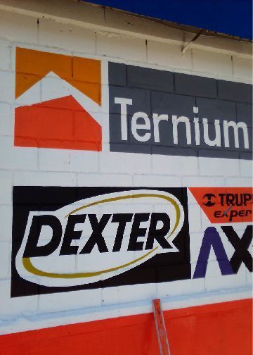 Un cartel de Ternium y Dexter está pintado en una pared de ladrillos.