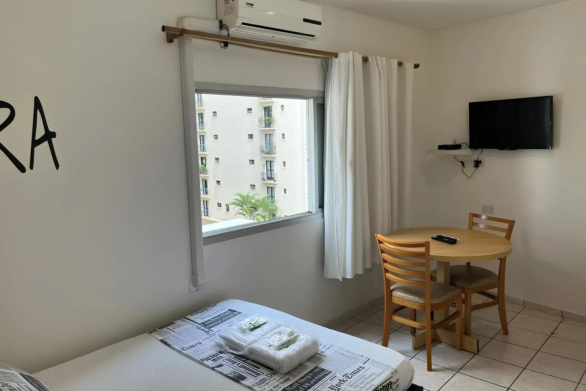 Um quarto com uma cama e uma luz na parede.