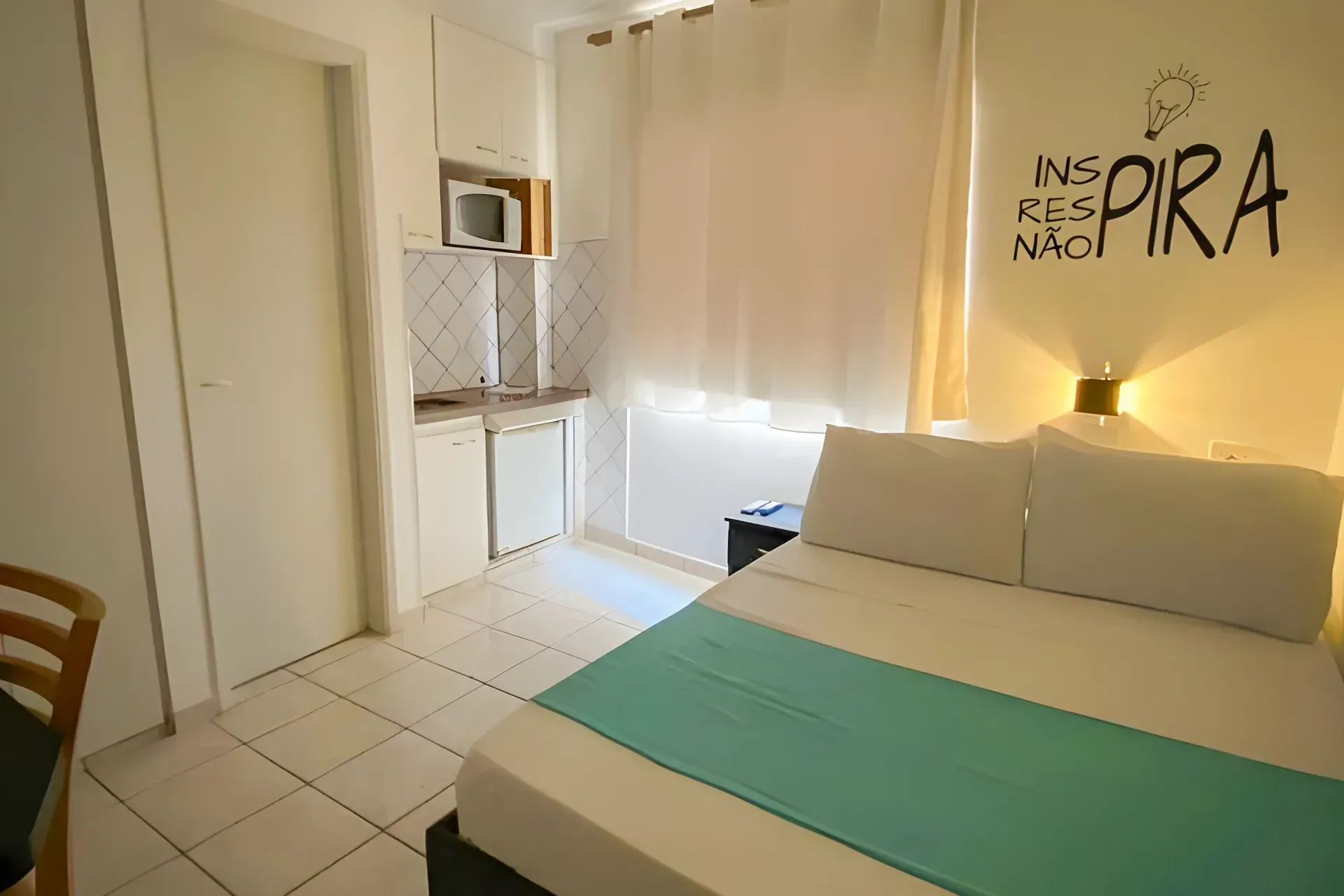 Um quarto de hotel com uma cama e uma janela.