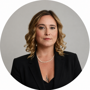 a woman wearing a pearl necklace and a black jacket is smiling .