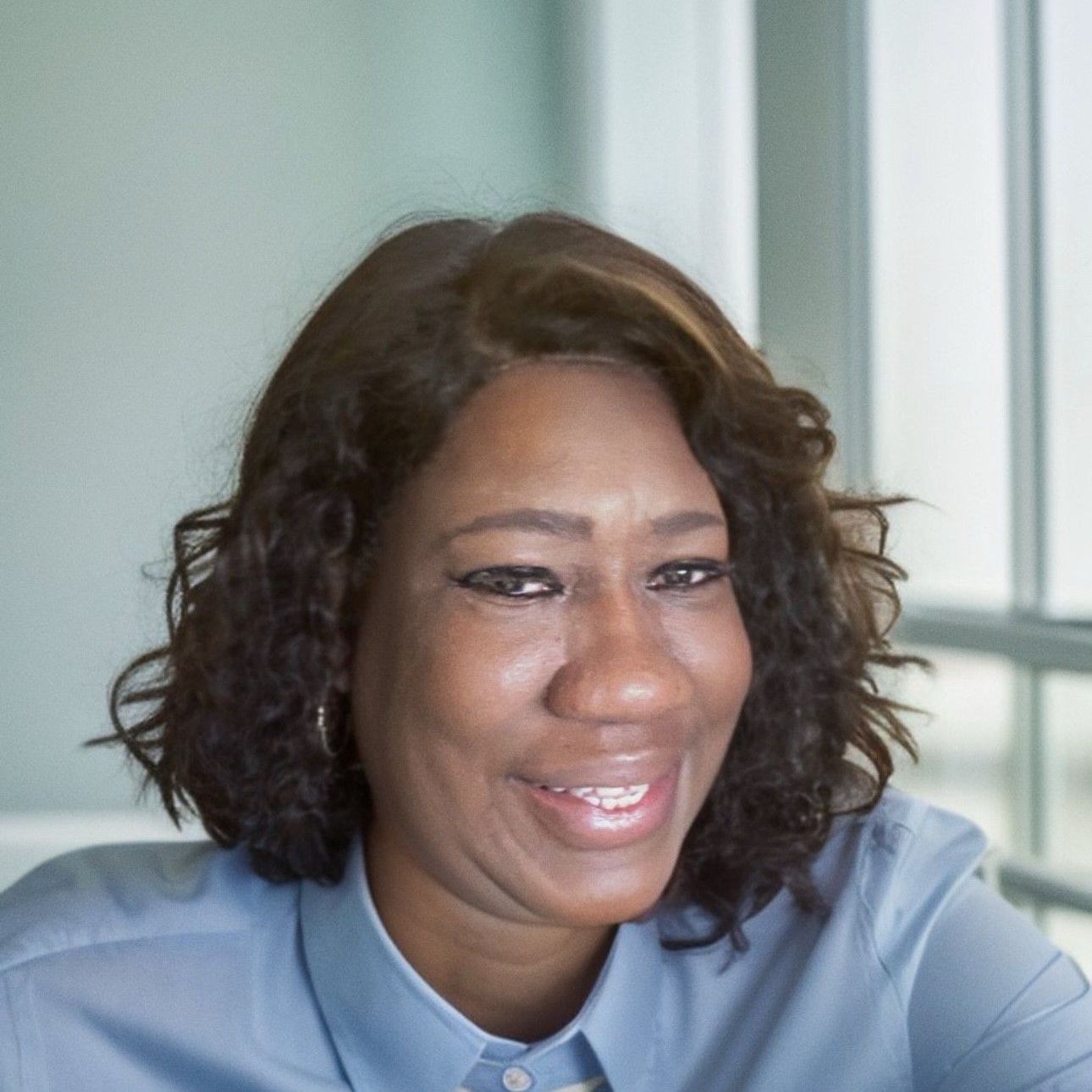 a woman wearing a blue blouse is smiling