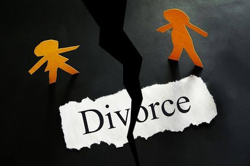 Two paper people are standing next to a piece of paper that says divorce