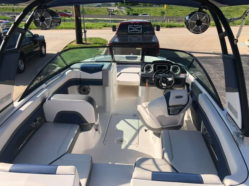 The inside of a boat with a steering wheel and seats
