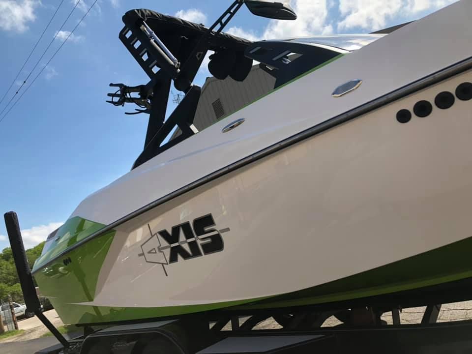 A green and white boat with the word vic on it