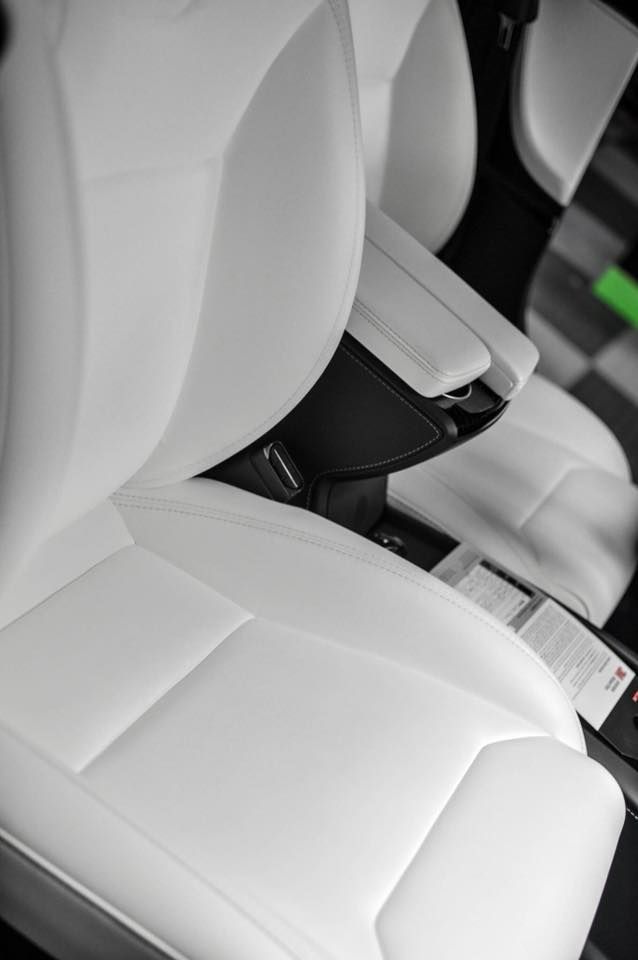 A close up of a white leather seat in a car.