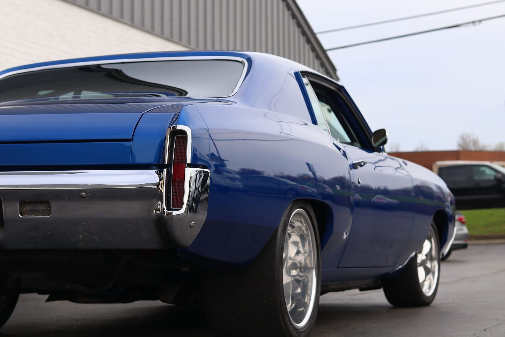 A blue car is parked in front of a building