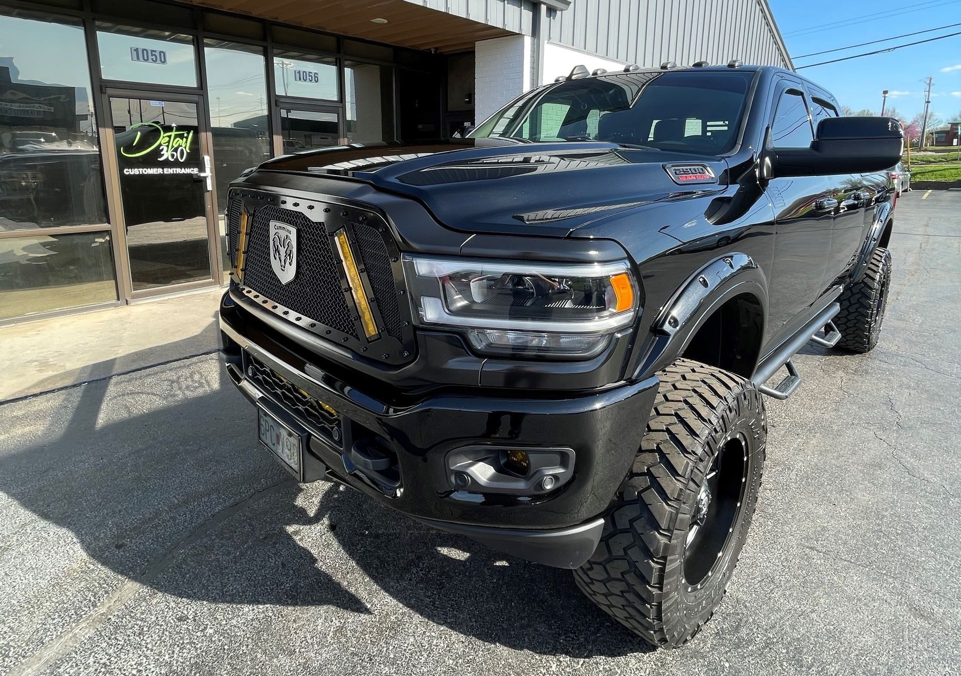 A black dodge ram truck is parked in front of a building.