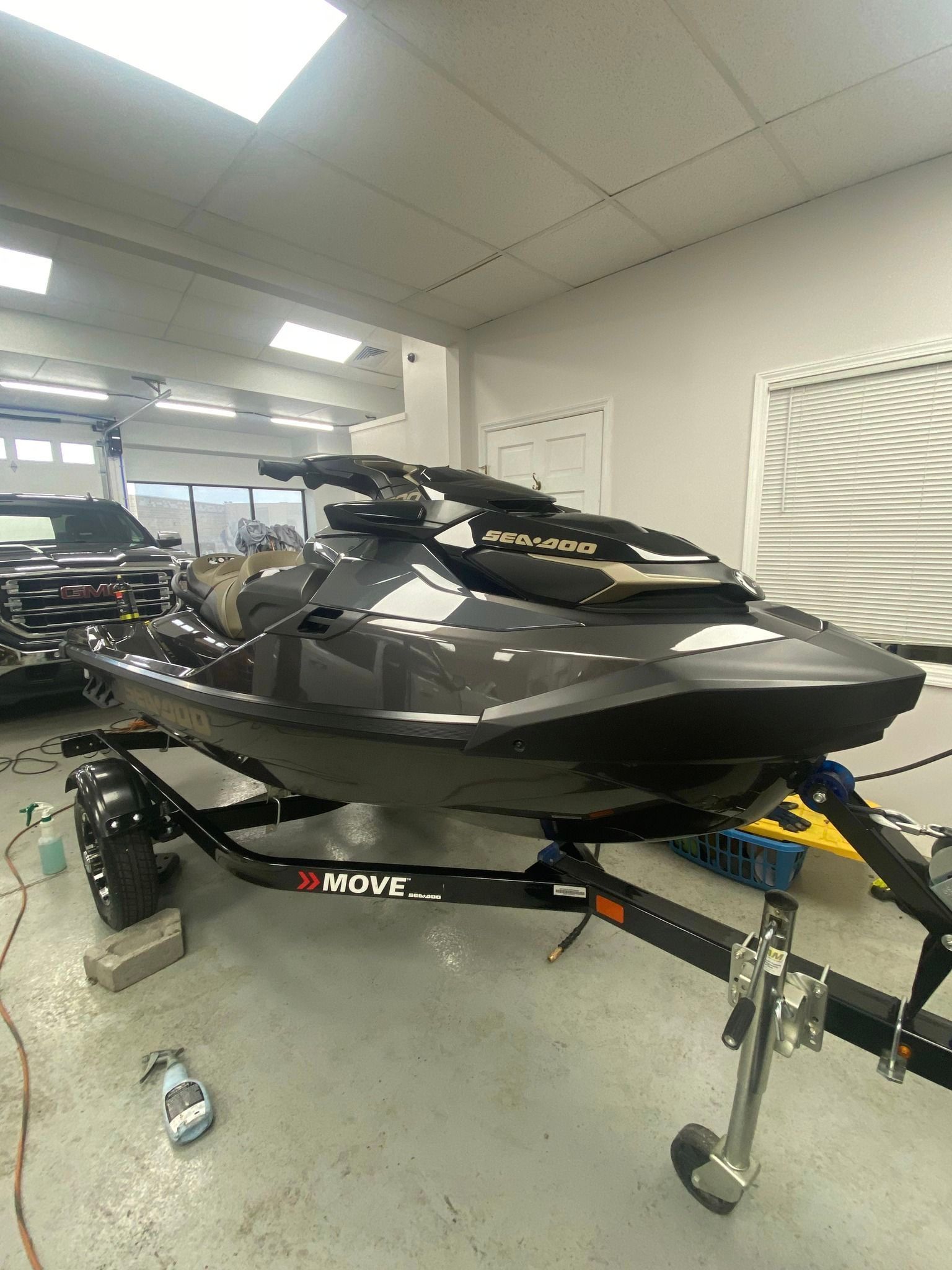 A jet ski is parked on a trailer in a garage.