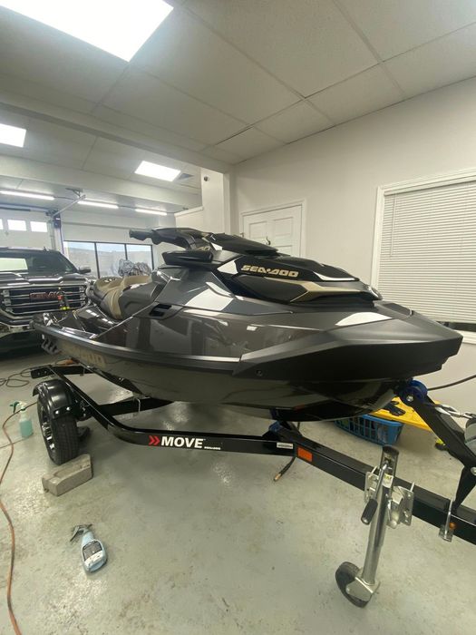 A jet ski is parked on a trailer in a garage.