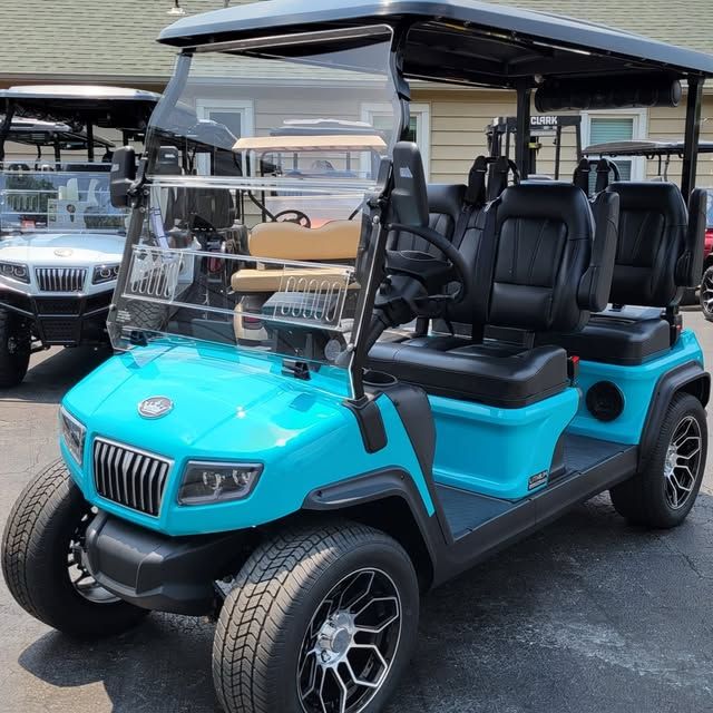 A white atv is parked on the side of a dirt road.