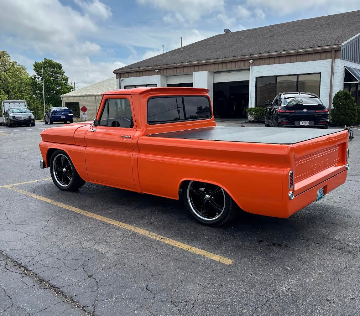 A red and green atv is parked in front of a building.