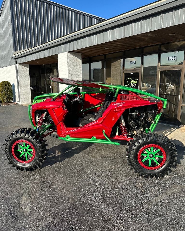 A white atv is parked on the side of a dirt road.