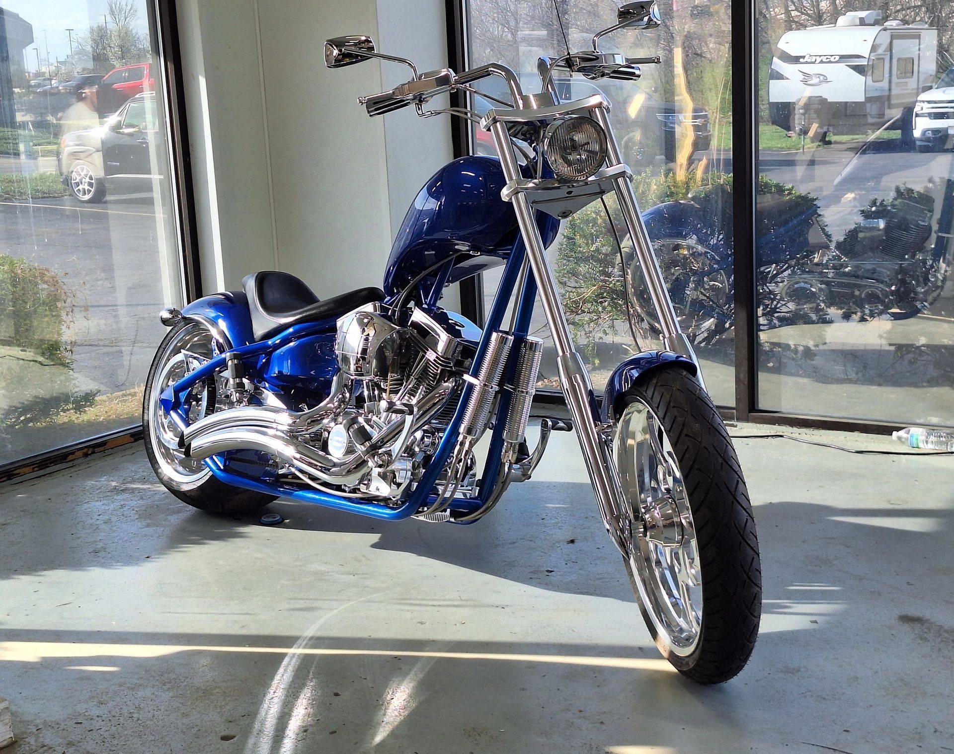 A man is cleaning a motorcycle in a garage.