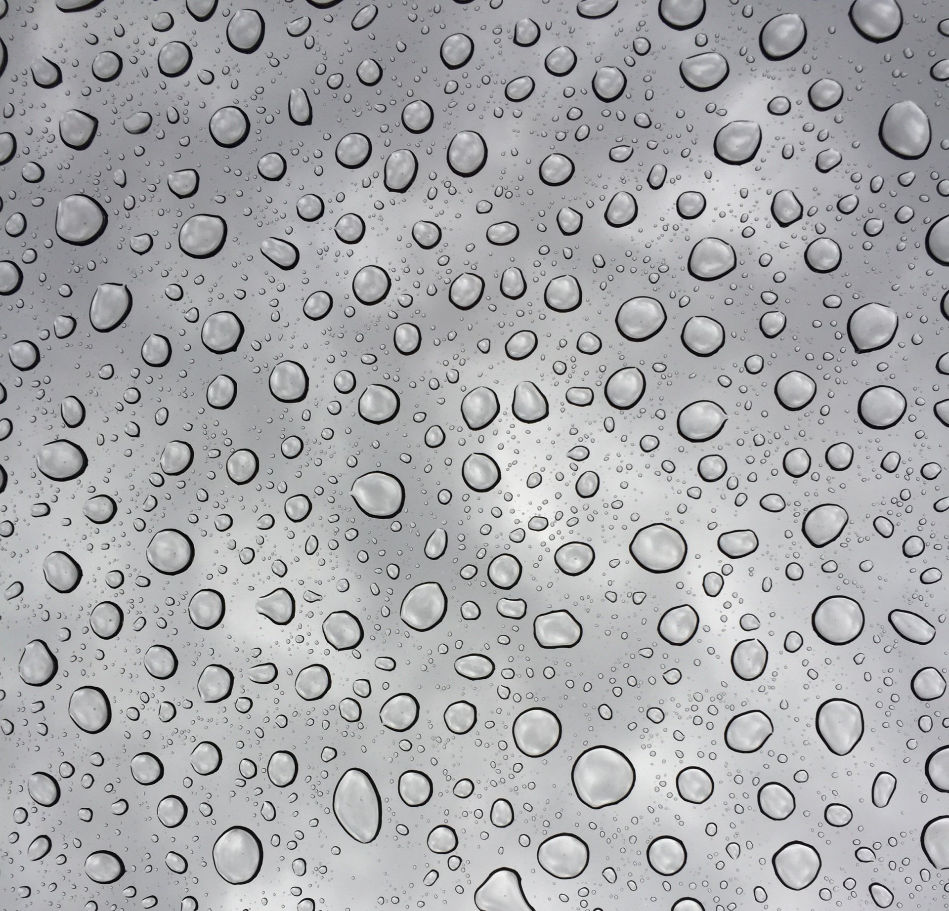 A man is cleaning a motorcycle in a garage.