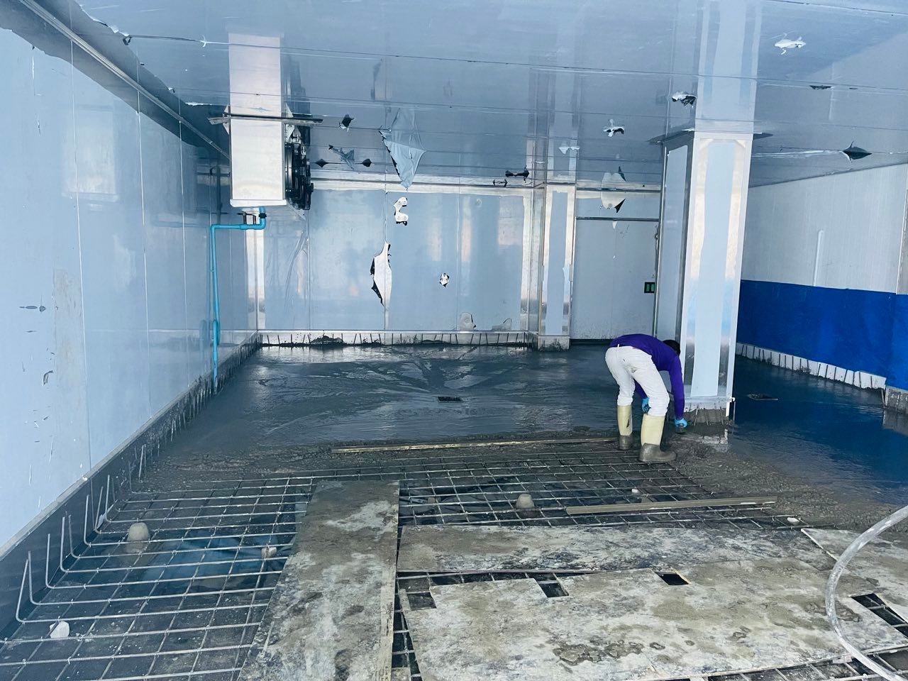 A man is working on the floor of an empty room.
