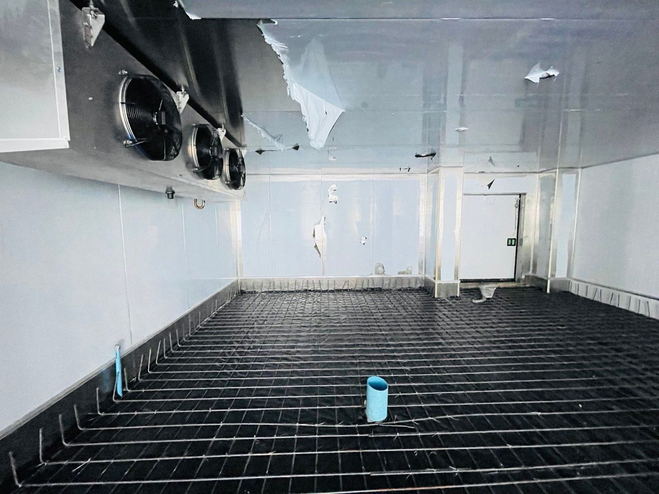 The inside of a refrigerator with a concrete floor.