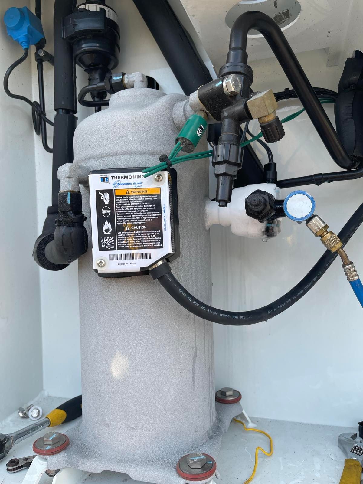 A close up of a compressor with a warning label on it