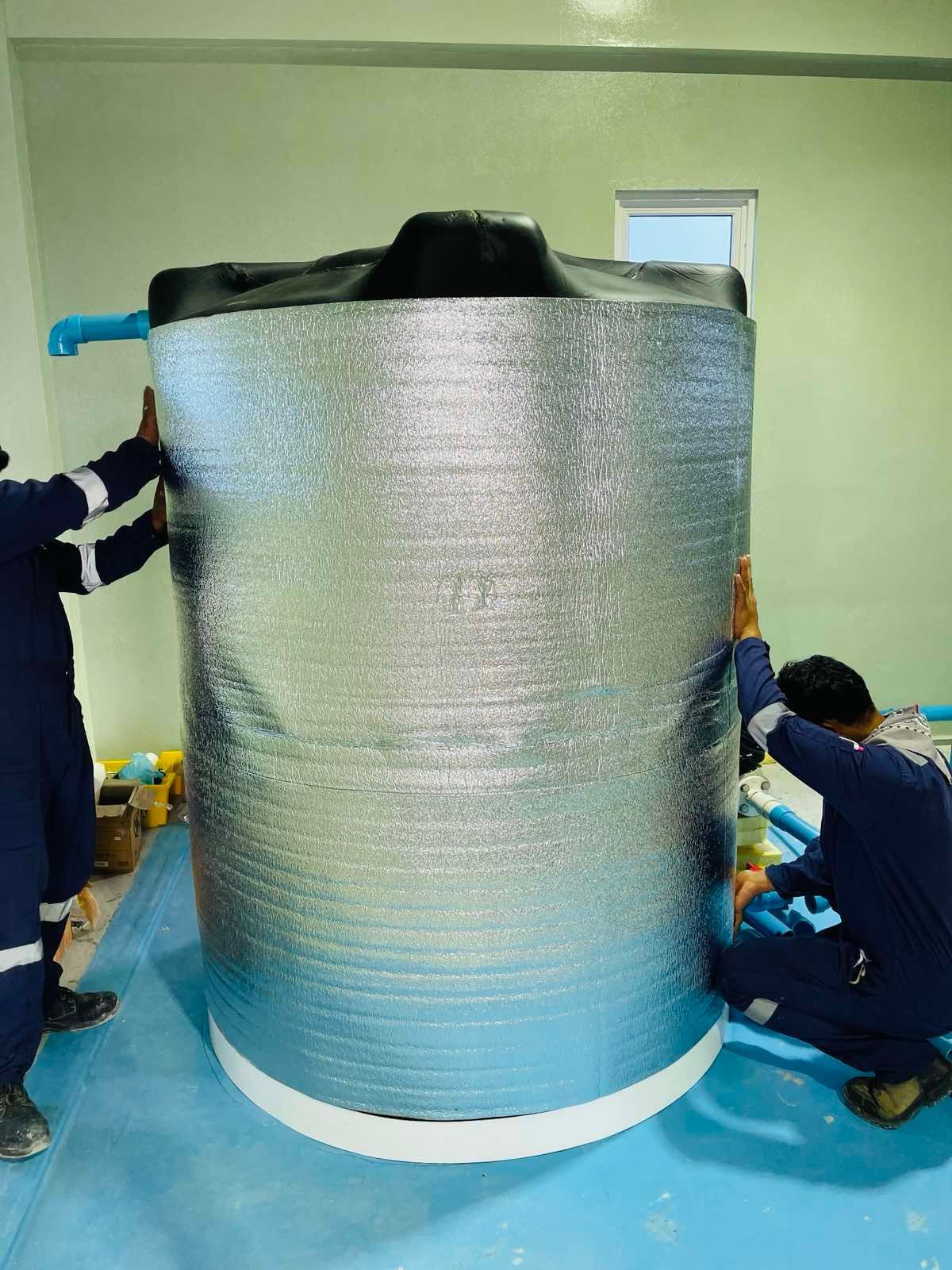 A group of men are working on a large cylindrical object.