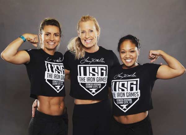 Three women flex their biceps, wearing black