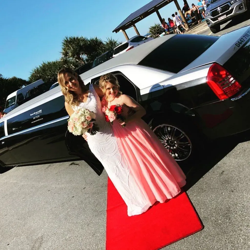 A Bride and Her Flower Girl Are Standing on a Red Carpet — Superstretch300 Limousines In Caloundra, QLD