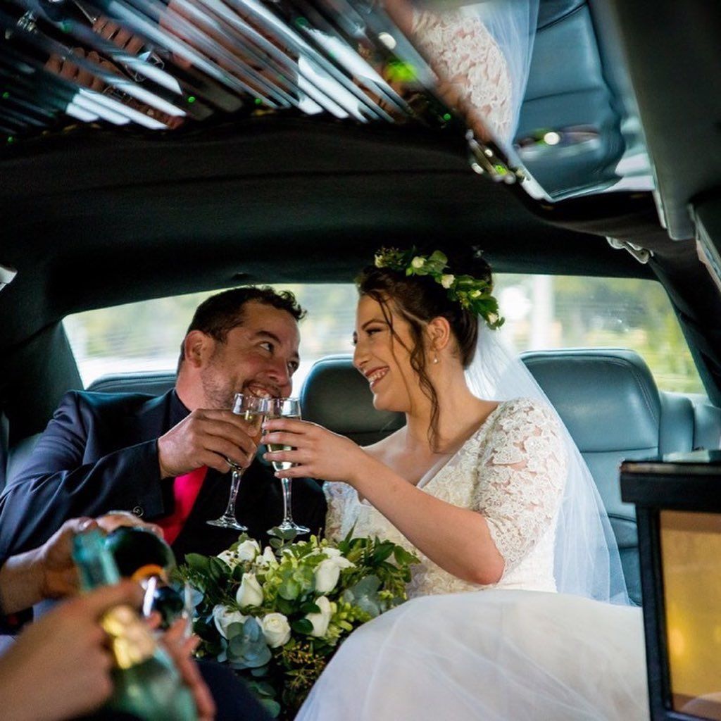 A Bride and Groom in a Limousine Toasting With Wine Glasses — Superstretch300 Limousines in Sunshine Coast, QLD