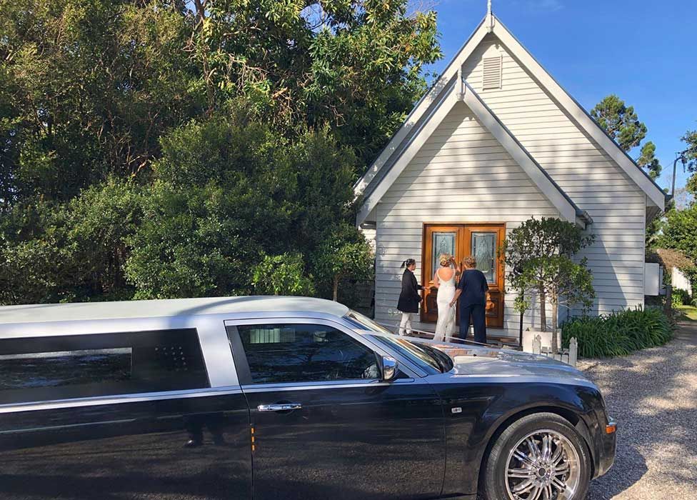 A Black Limousine is Parked in Front of a Small White Church — Superstretch300 Limousines in Sunshine Coast, QLD