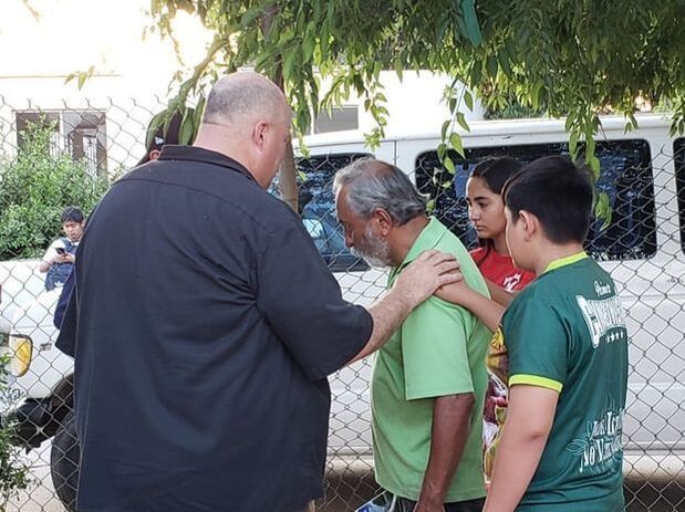 Pastor Jeremy prays for a man who asked to receive Christ. He sits between a circle of brothers in Haiti,
