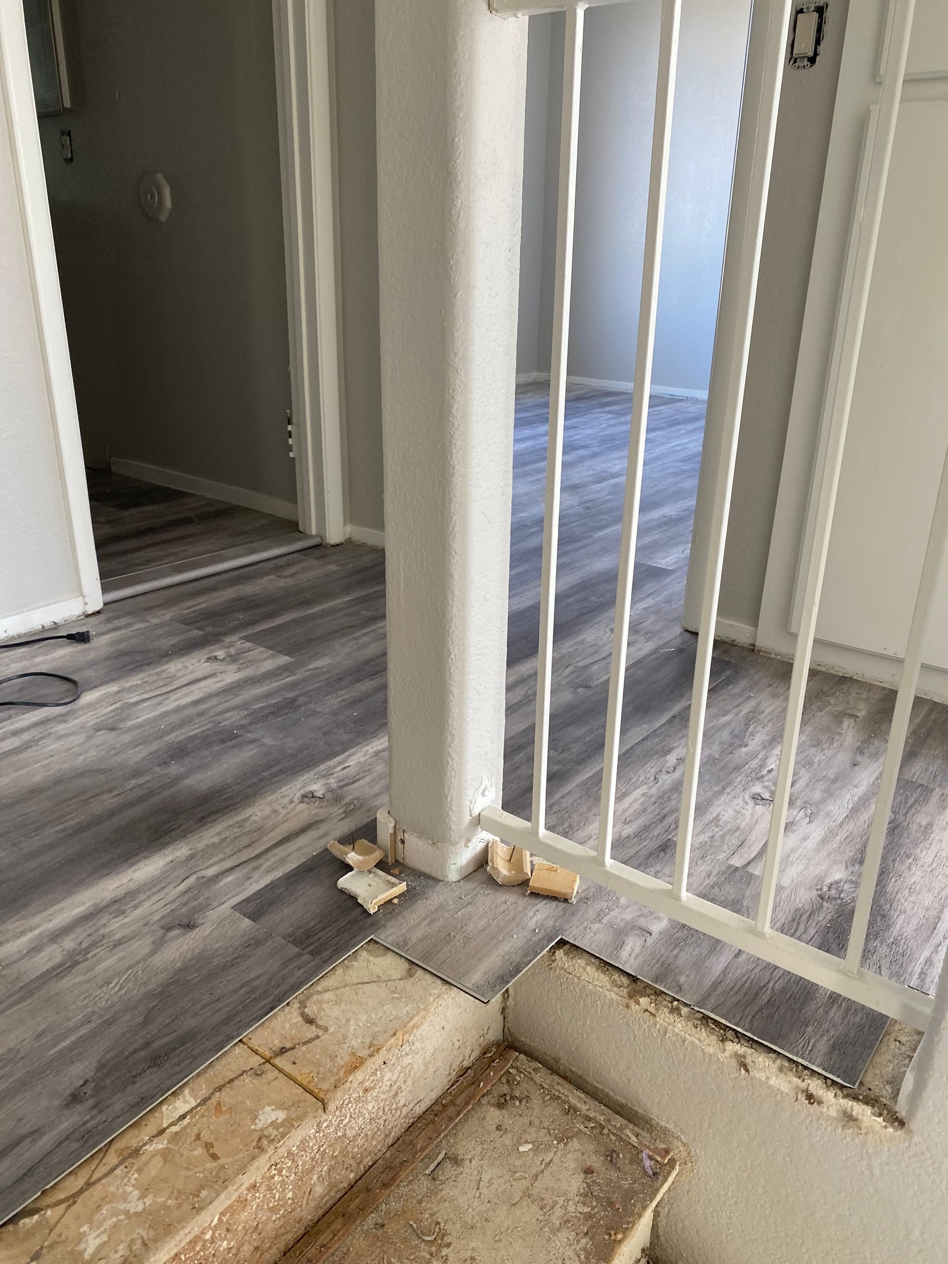 A staircase in a house with a white railing and a wooden floor.