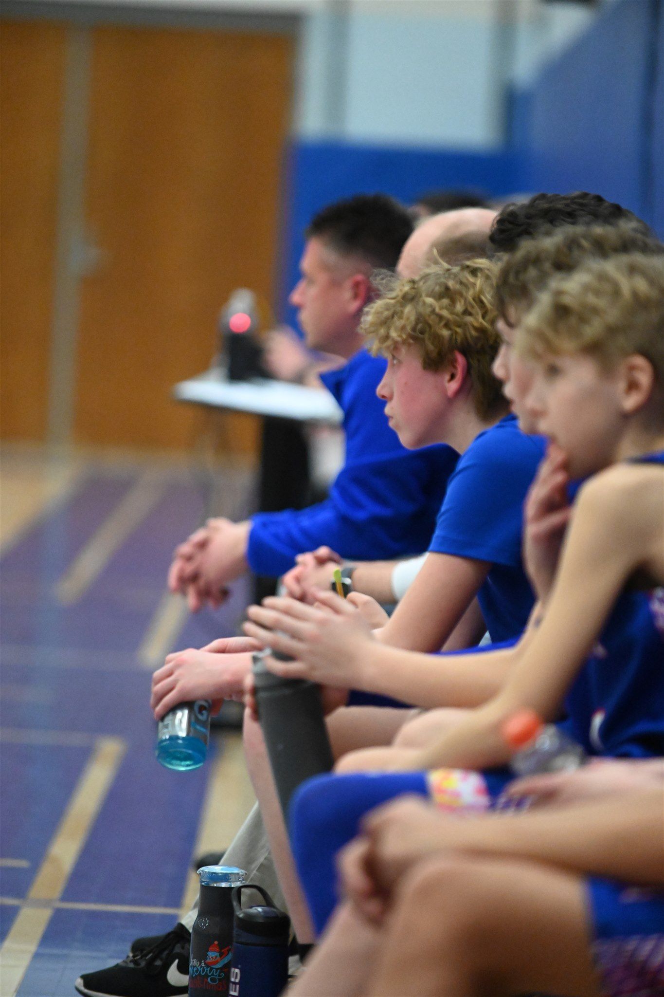 member of the 2023-24 boys basketball team on the sidelines