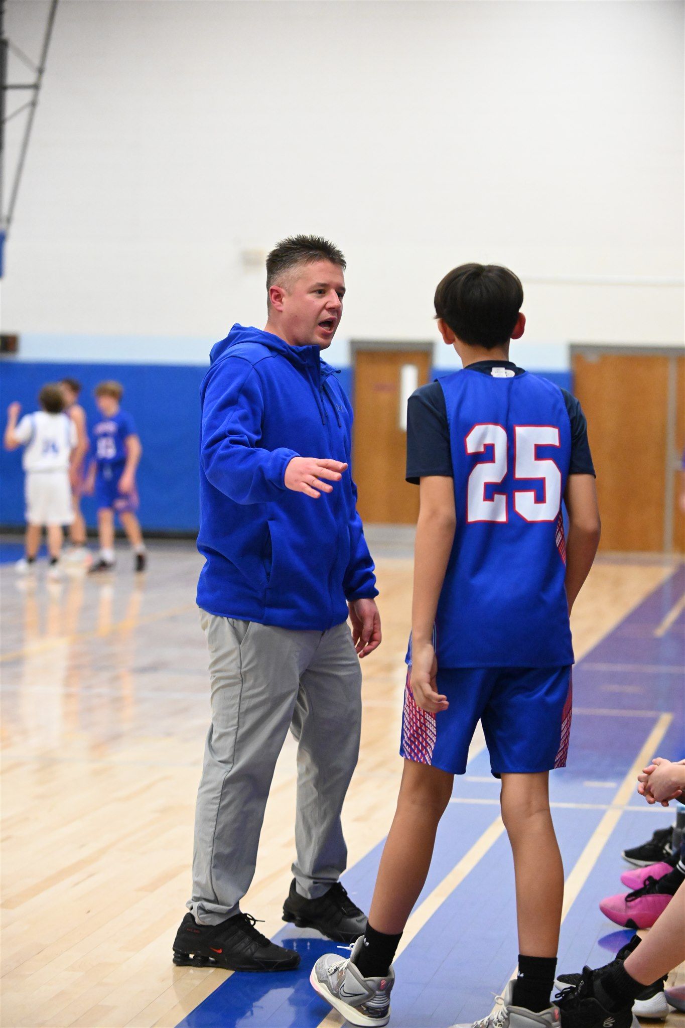 member of the 2023-24 boys basketball team talking with the coach 