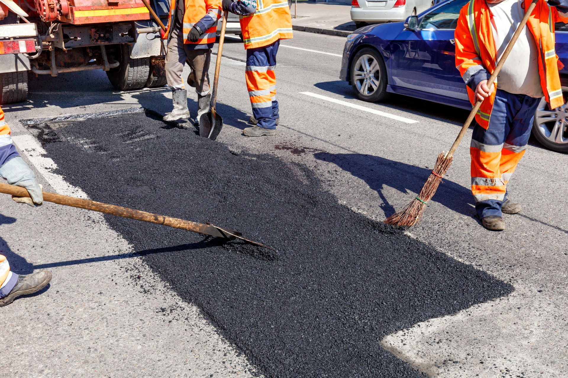 A group of construction workers are working on a road.
