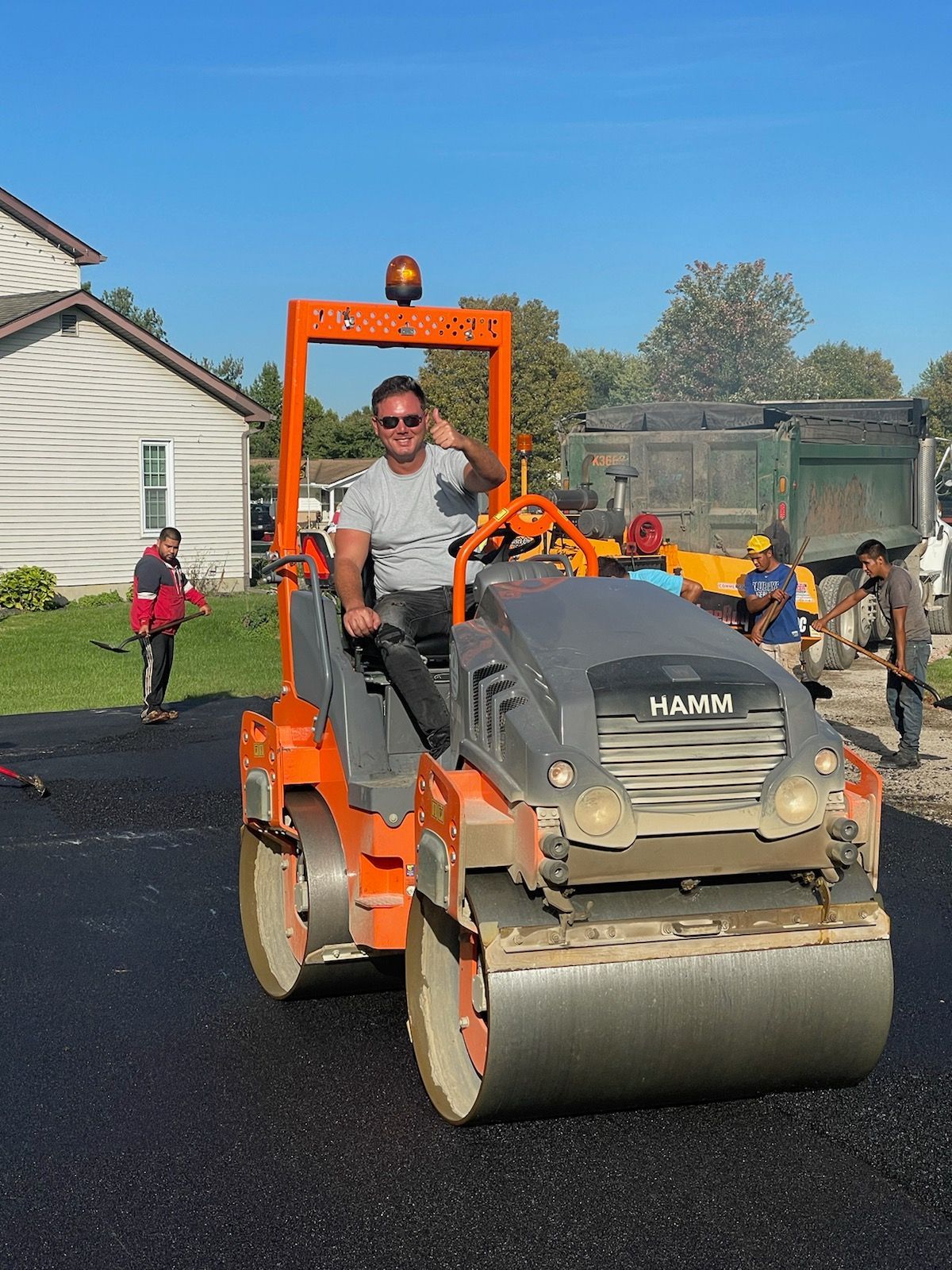 A man is driving a roller on a road.