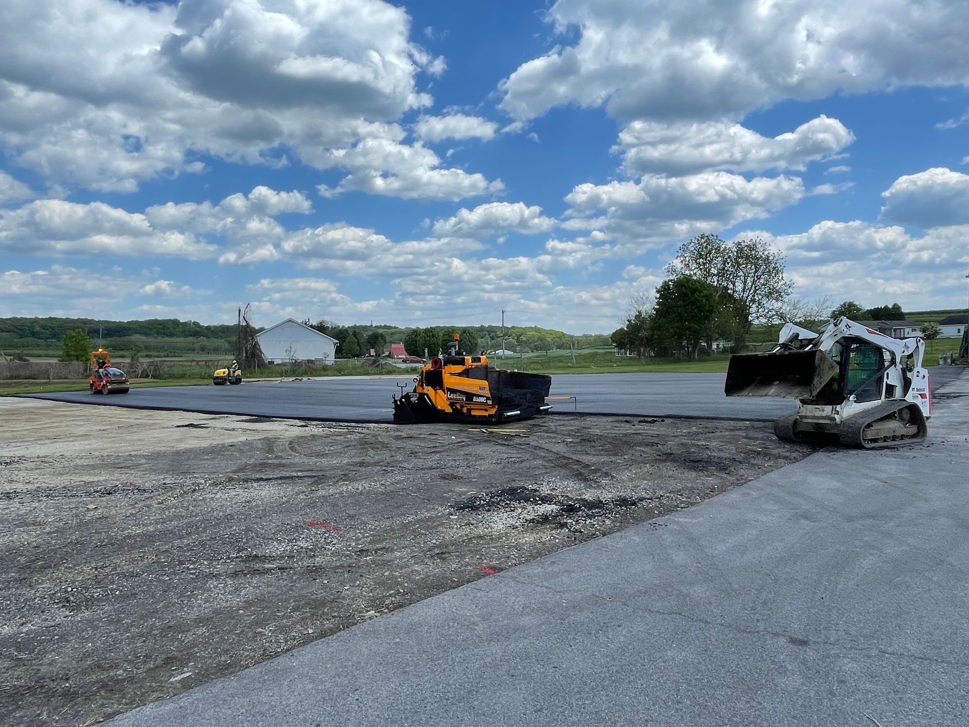 A group of construction vehicles are working on a road.