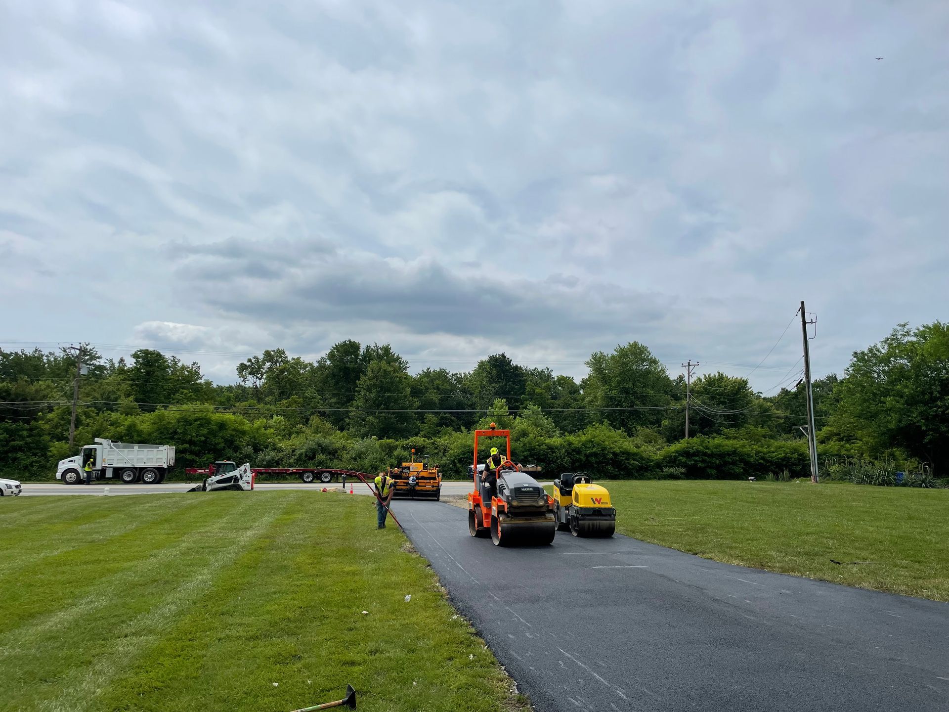 A group of construction vehicles are working on a road.