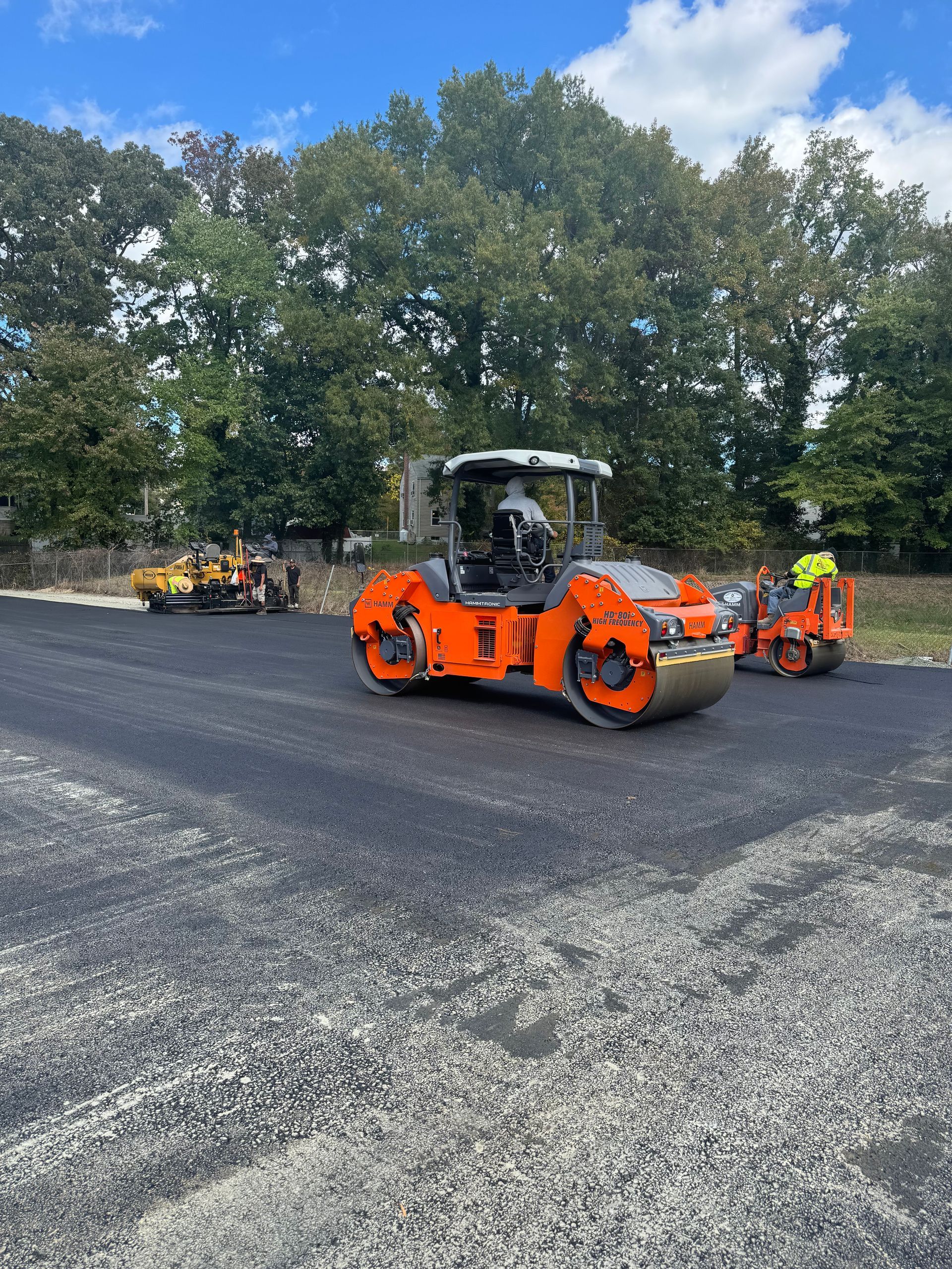 A group of construction vehicles are driving down a road.