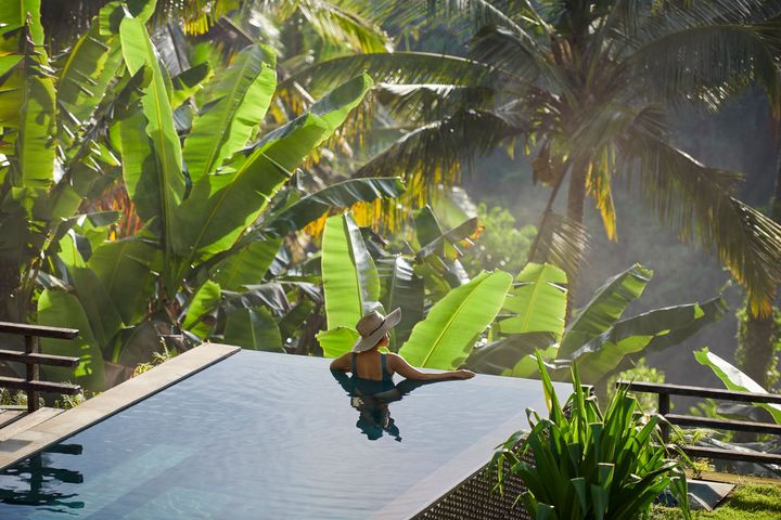 Woman in jungle infinity pool.