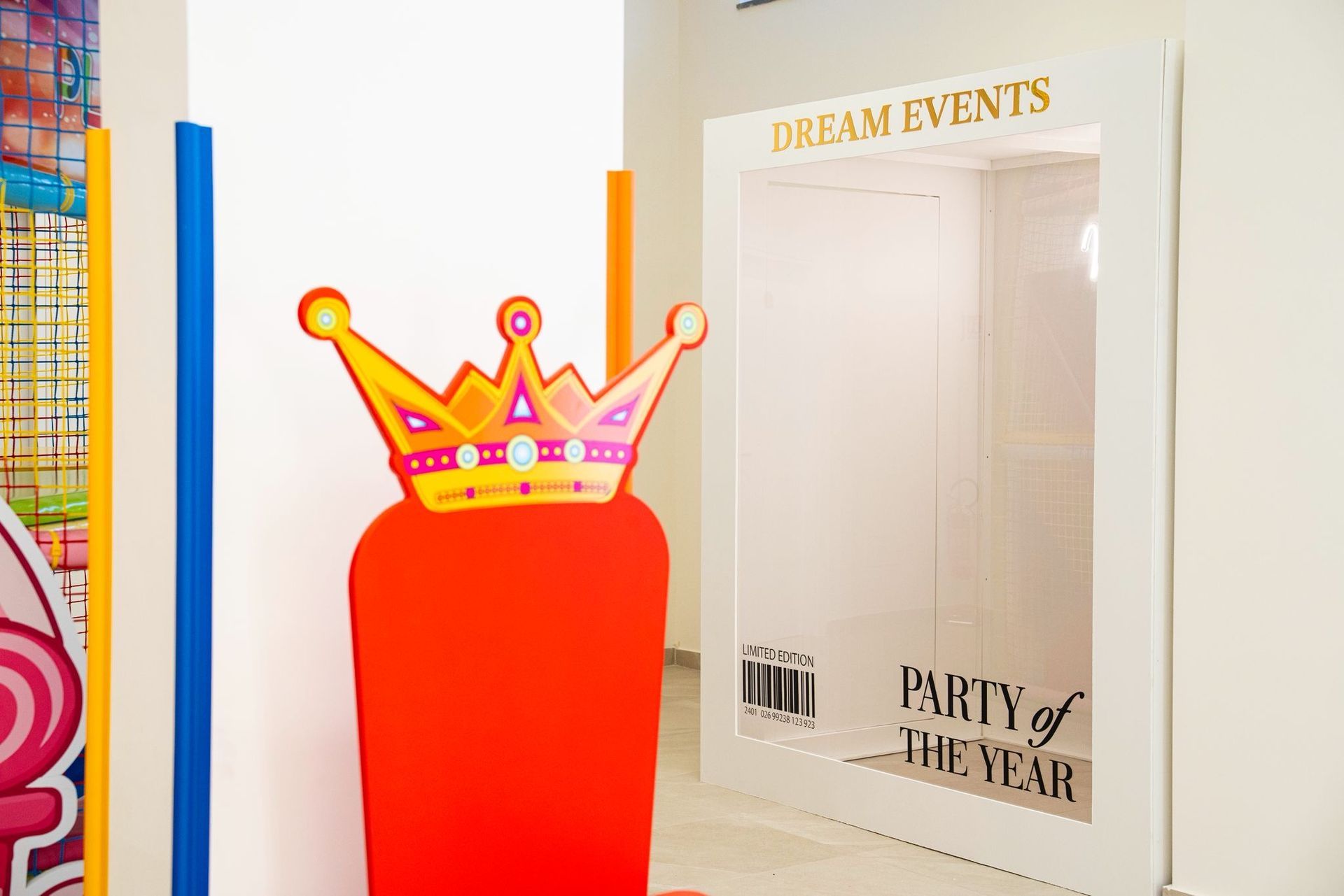 Una sagoma di cartone rosso a forma di sedia con una corona, accanto a una sagoma di cornice per foto .