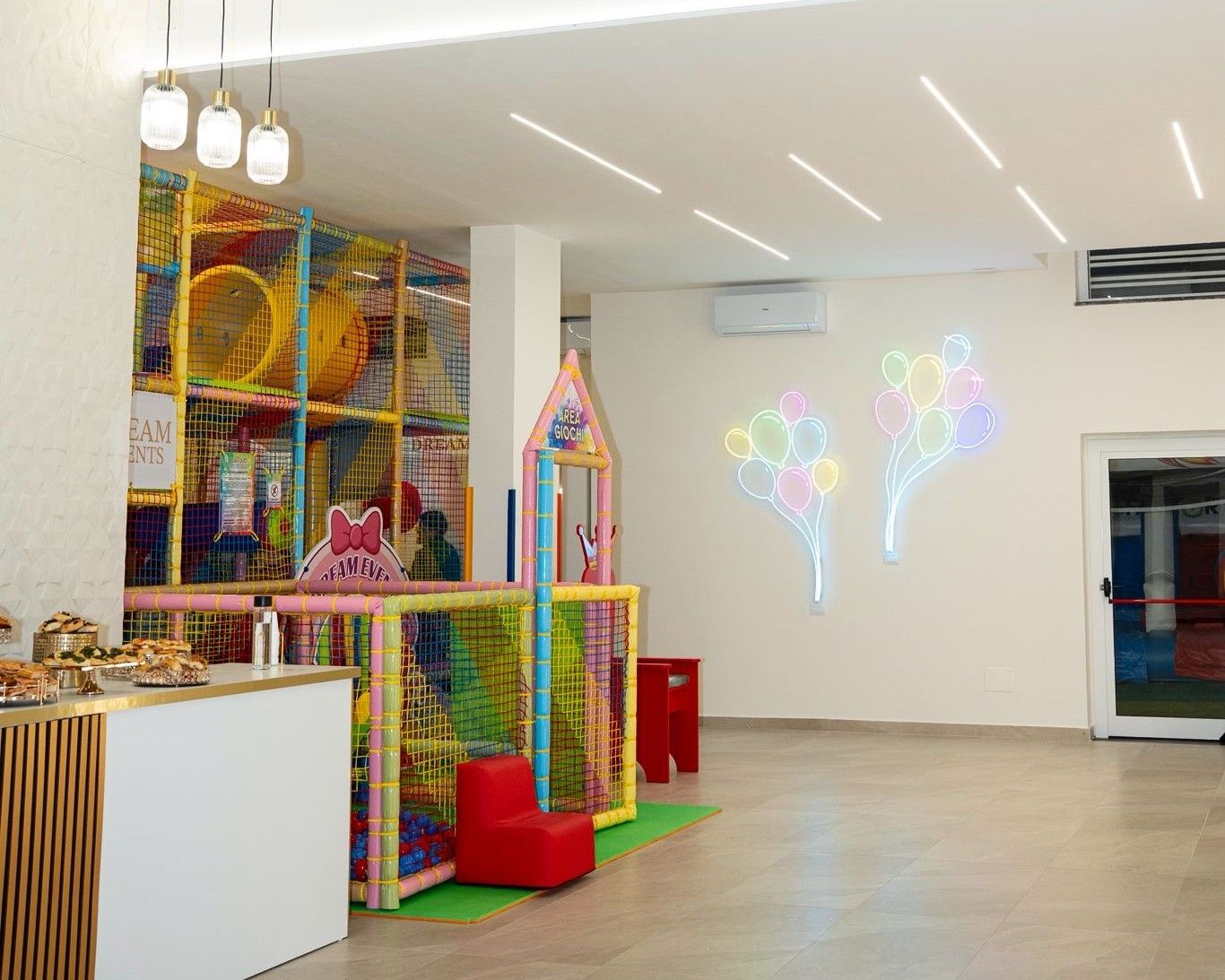 Una festa per il 30° compleanno con una parete di palloncini rosa e viola, una torta a più piani e numeri luminosi.