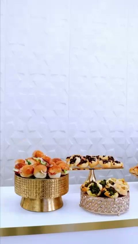 Un lungo tavolo coperto da una tovaglia bianca, imbandito con una varietà di antipasti, stuzzichini e arance fresche.