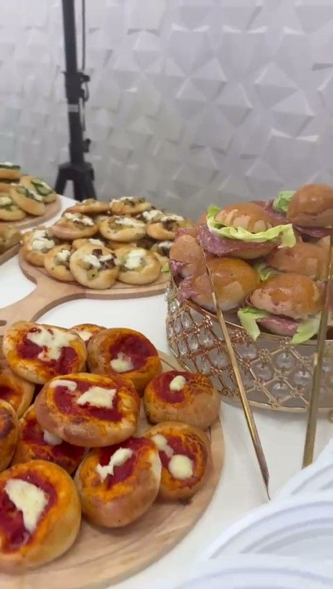 Una composizione di crostini assortiti con formaggio, erbe aromatiche e frutta, disposti su un'alzatina di vetro.