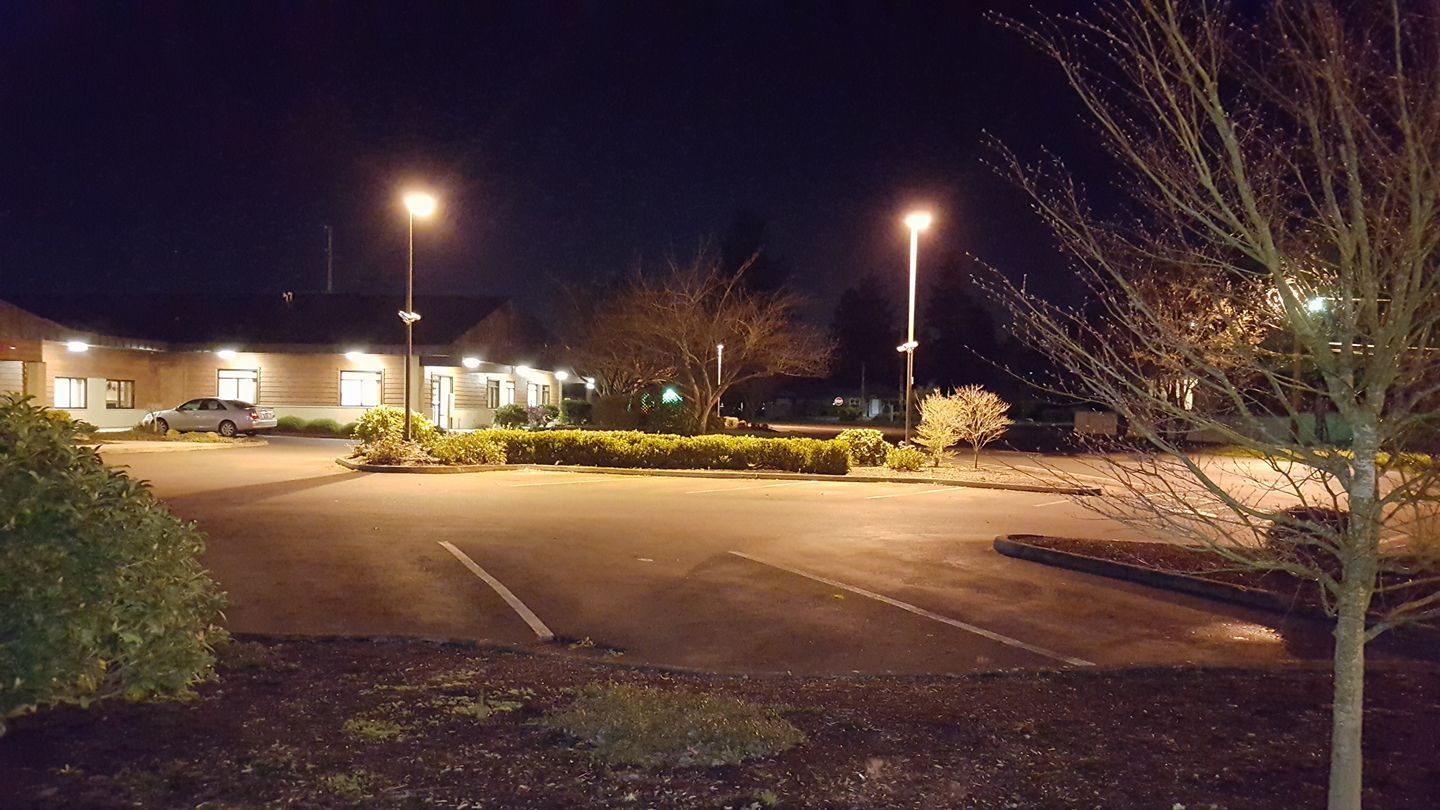 A parking lot with a building in the background at night