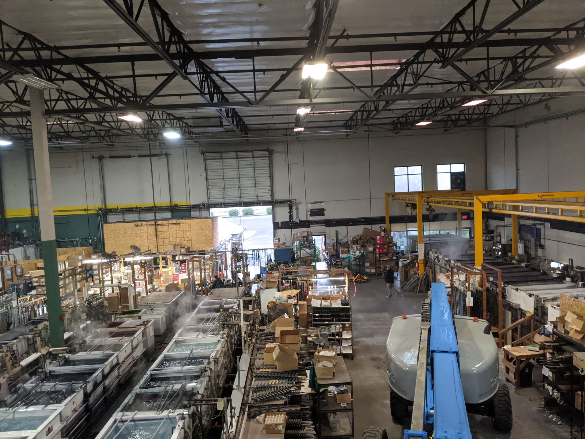A man is fixing a light fixture in a living room.