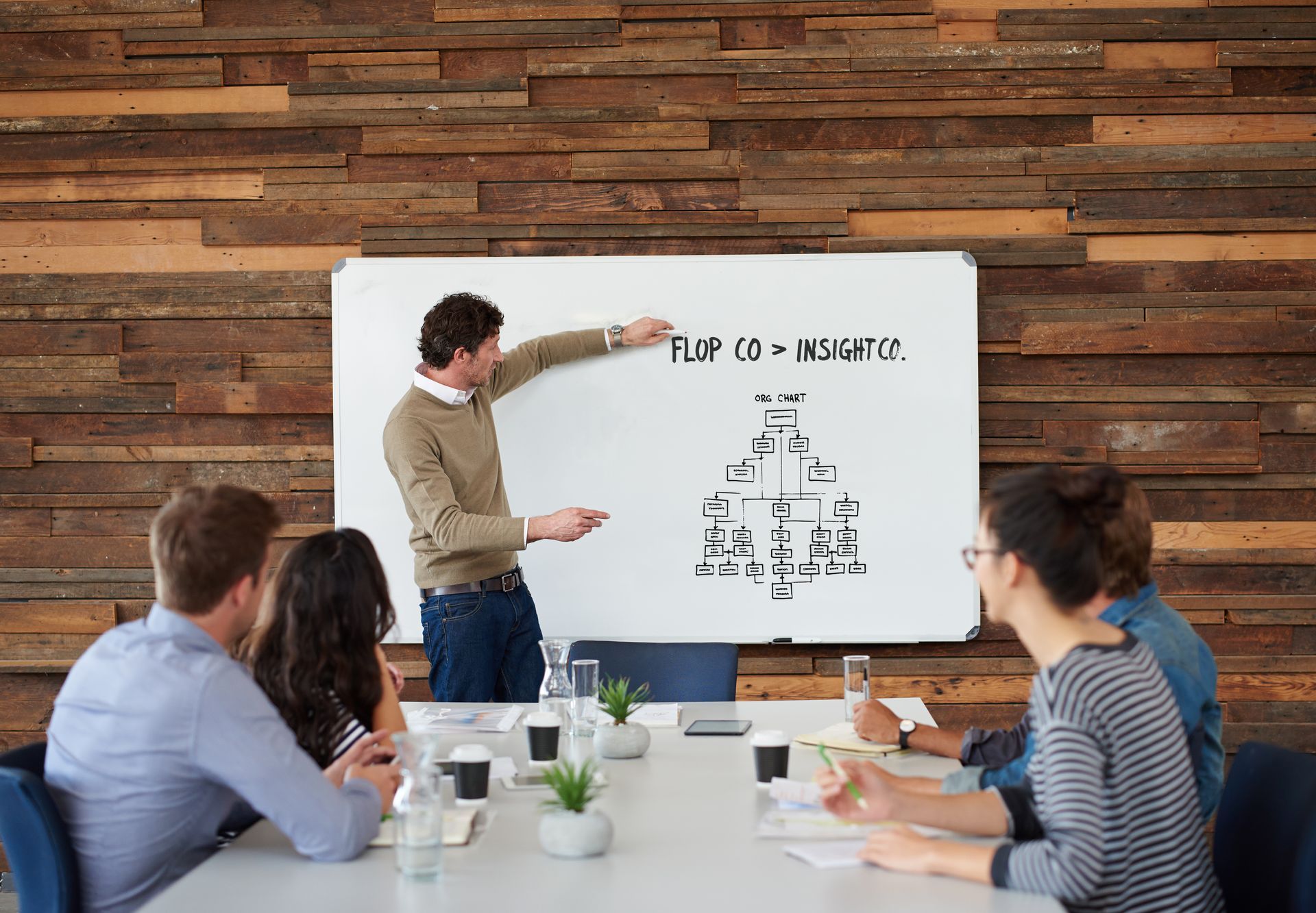 A man is giving a presentation to a group of people at a conference table.