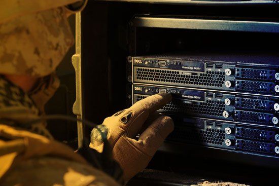A man in a military uniform is working on a server
