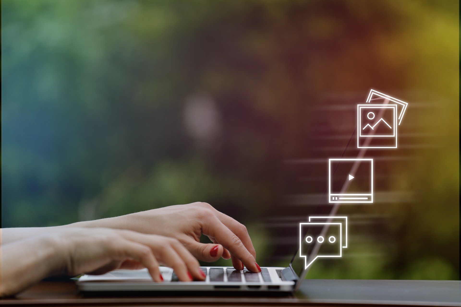 A woman is typing on a laptop computer with icons coming out of it.