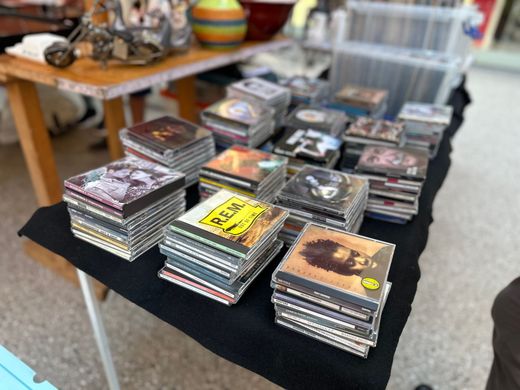 Stapel von CD-Hüllen und Schallplatten lagen auf einem schwarzen Tisch an einem Marktstand.