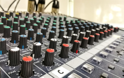 A close up of a mixer with many knobs and buttons