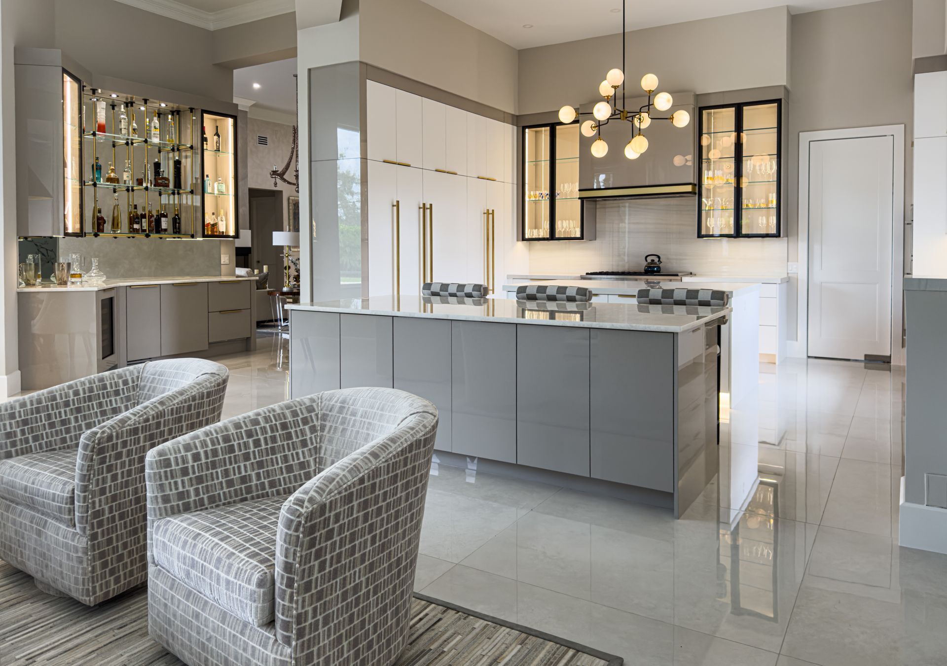 A kitchen with two chairs and a large island in the middle.