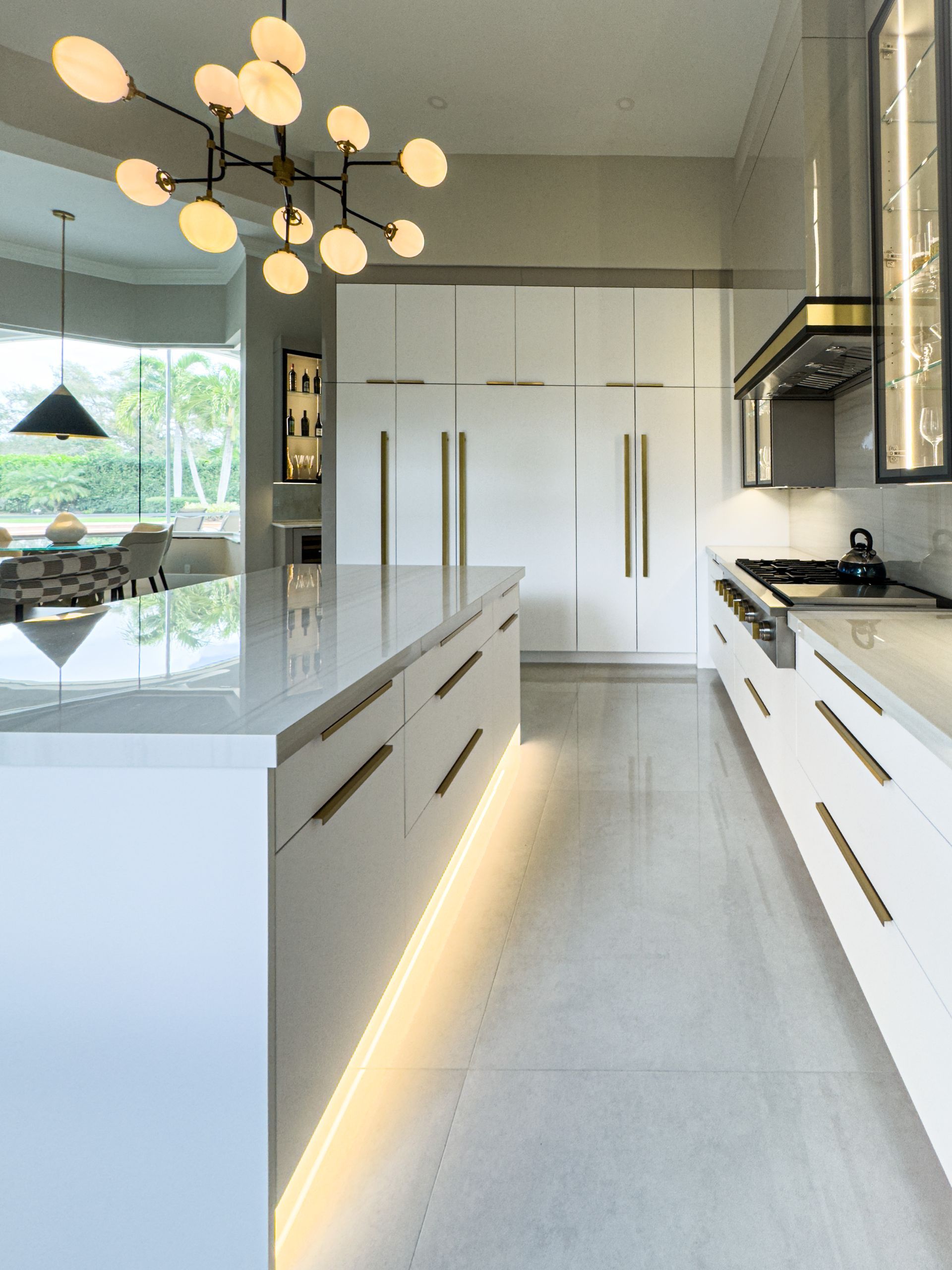 A kitchen with white cabinets , and a large island.