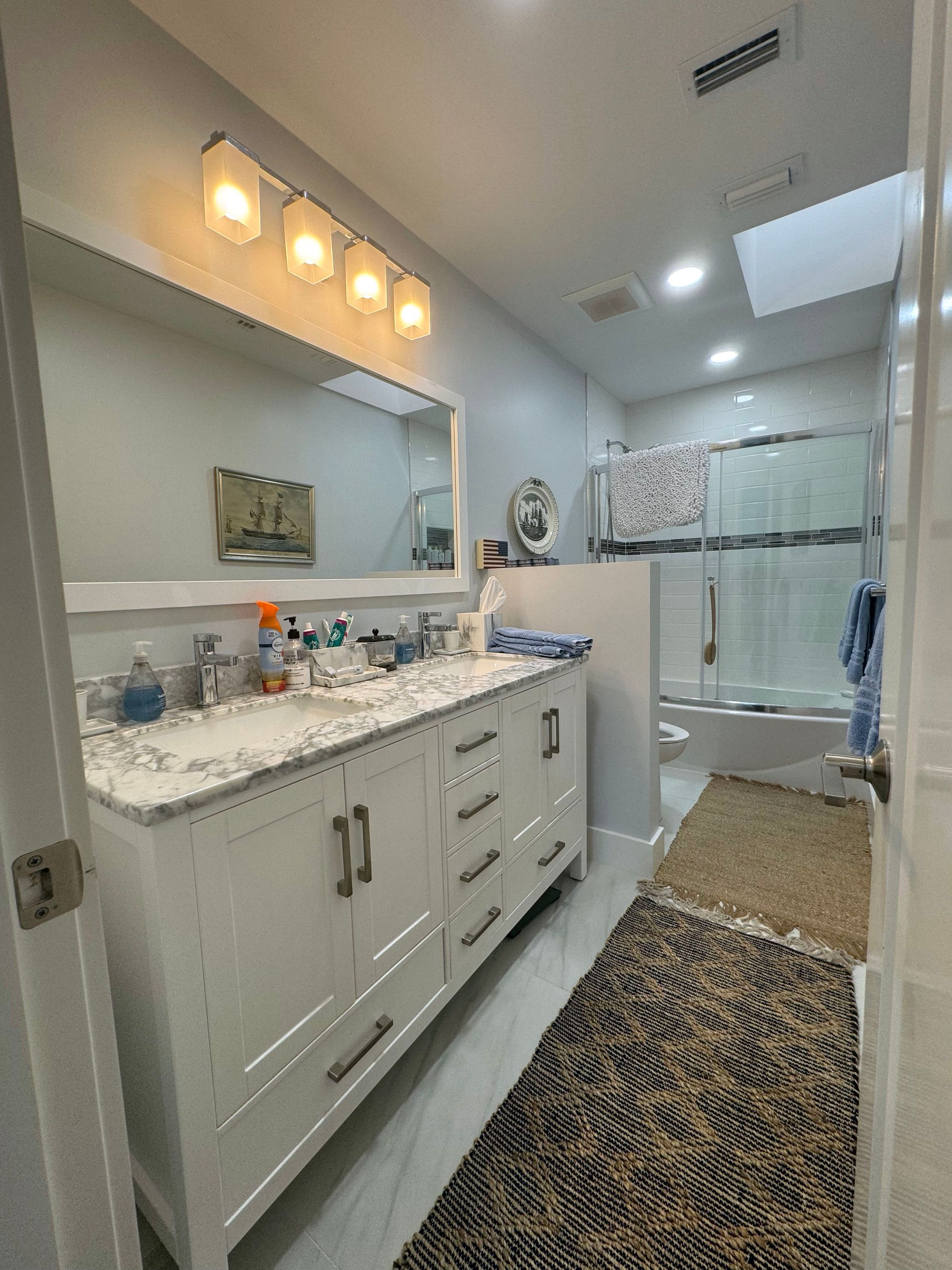 A bathroom with two sinks , a mirror and a shower.